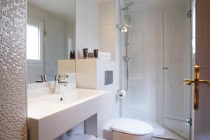 salle d'eau blanche avec douche , lavabo et toilettes Hôtel des Deux Continents paris 6