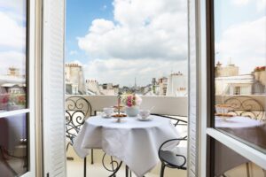 fenêtre ouverte sur balcon avec vue et table dressée pour le petit-déjeuner - hotel trianon rive gauche paris