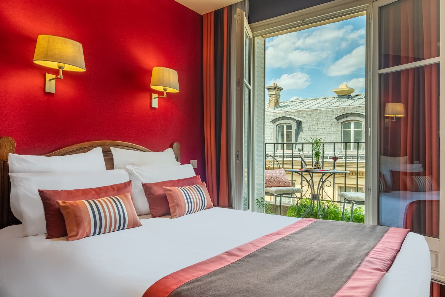 chambre avec lit double, tissus rouge et fenêtre ouverte sur Paris - hotel trianon rive gauche paris